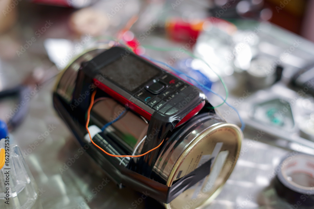 Homemade bomb with a cellphone timer, on a blurred background Homemade bomb with a cellphone timer, on a blurred background