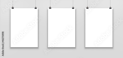 Фотография Three blank paper poster mockup isolated on a gray background.
