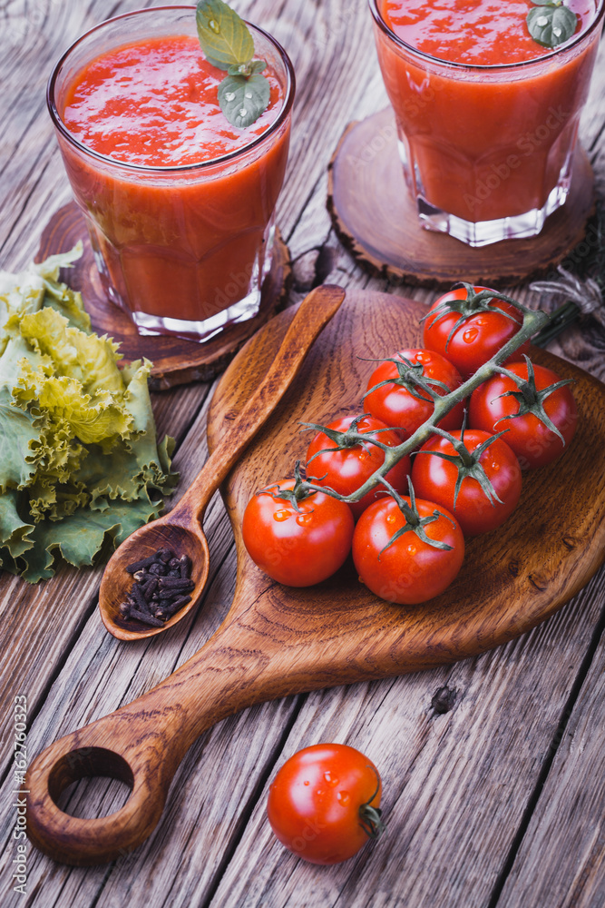 fresh tomato juice and Tomato branch on a wooden cutting board fresh tomato juice and Tomato branch on a wooden cutting board