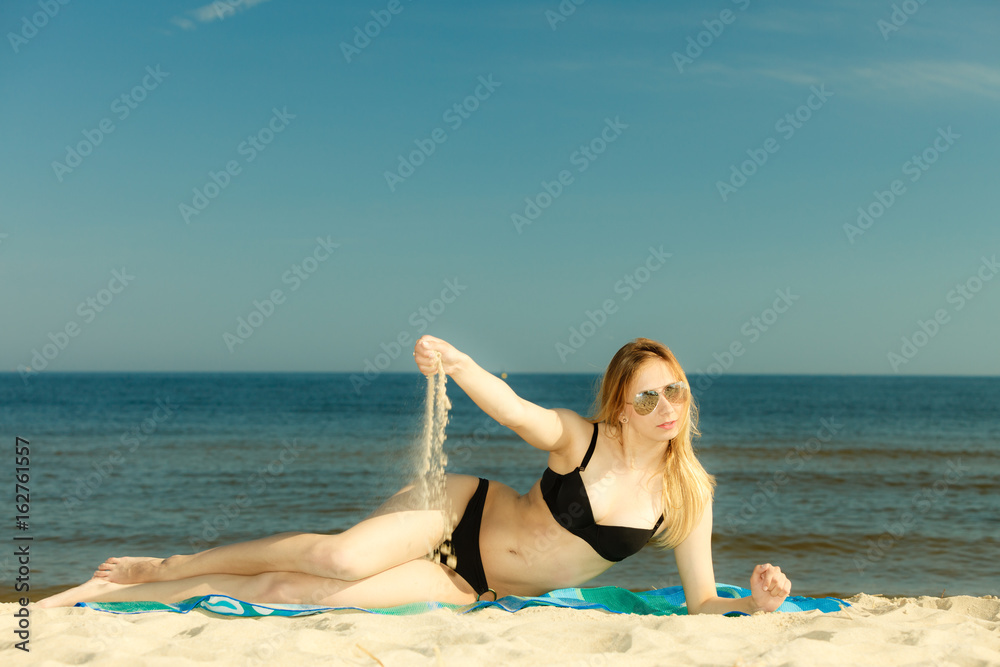 Woman in bikini sunbathing and relaxing on beach Woman in bikini sunbathing and relaxing on beach