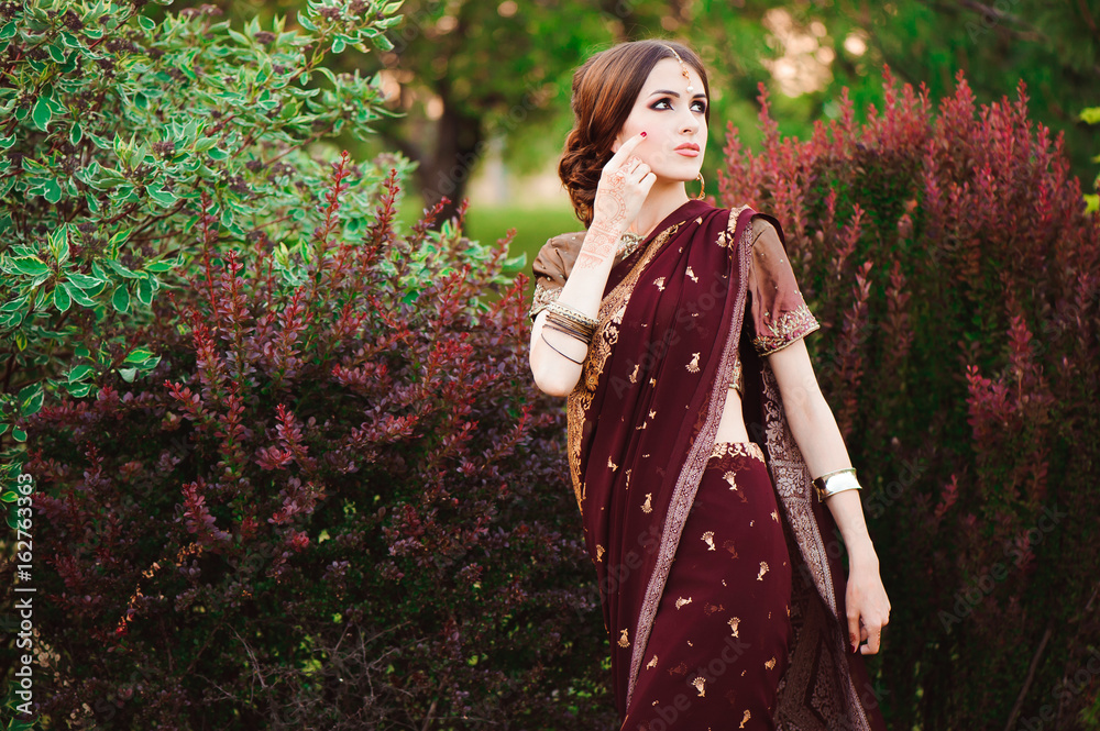 Portrait of beautiful indian girl. Young hindu woman model with tatoo mehndi and kundan jewelry. Traditional Indian costume saree. Portrait of beautiful indian girl. Young hindu woman model with tatoo mehndi and kundan jewelry. Traditional Indian costume saree.