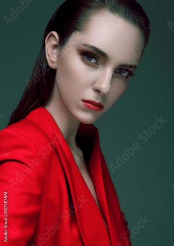Fashion model with wet hair wearing red long coat