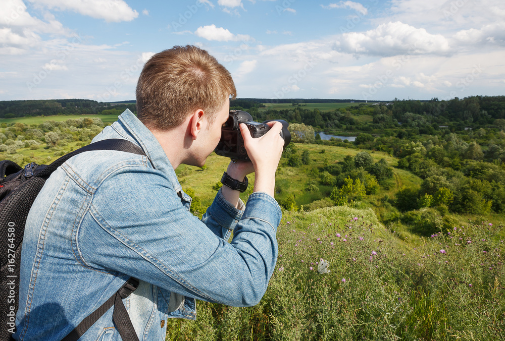 a young photographer photographing a landscape a young photographer photographing a landscape