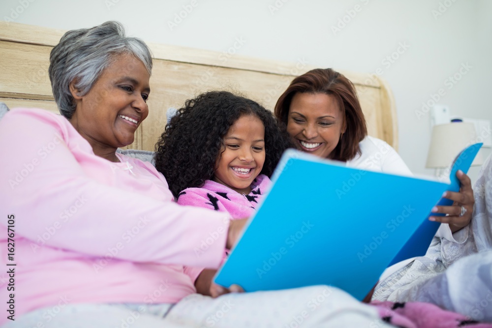Fototapeta premium Family watching photo album together in living room