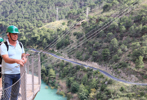 Hikers walking along the wooden walkways of the gorge of Los Gaitanes, in the Caminito del Rey, Malaga, Spain