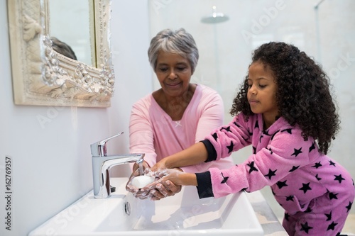 Grandmother and granddaughter washing hands 