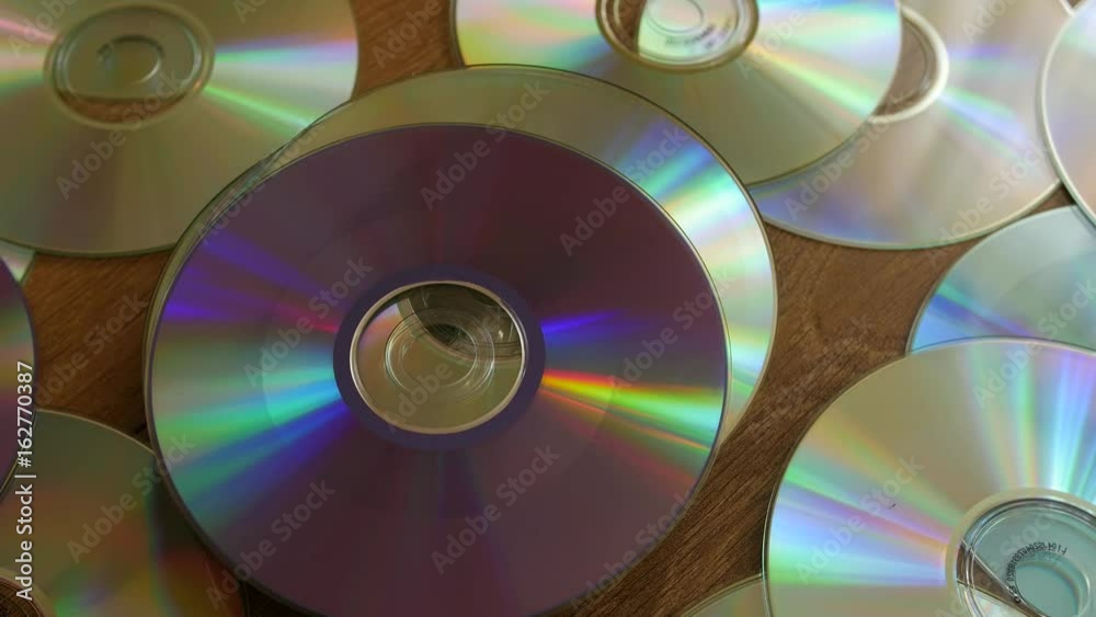 Optical Discs falling onto big pile of DVDs or CDs. Optical Discs falling onto big pile of DVDs or CDs.