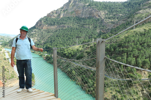 Man posing on the wooden walkways of the gorge of Los Gaitanes, Caminito del Rey, Malaga, Spain