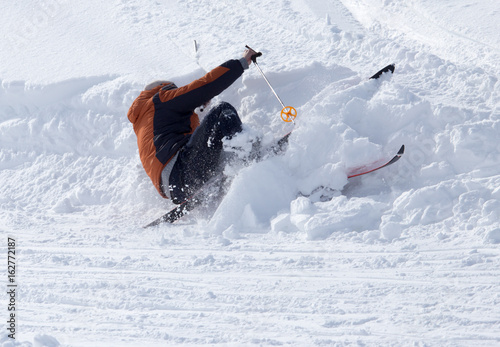 The skier fell in the snow at speed