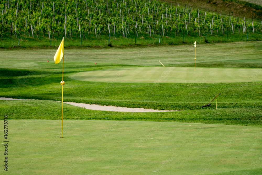 Obraz premium Golf course in vineyards with yellow flag posts and bunker