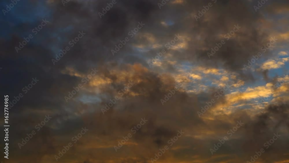 The sky is covered with dense clouds painted with the bright color of the setting sun The sky is covered with dense clouds painted with the bright color of the setting sun