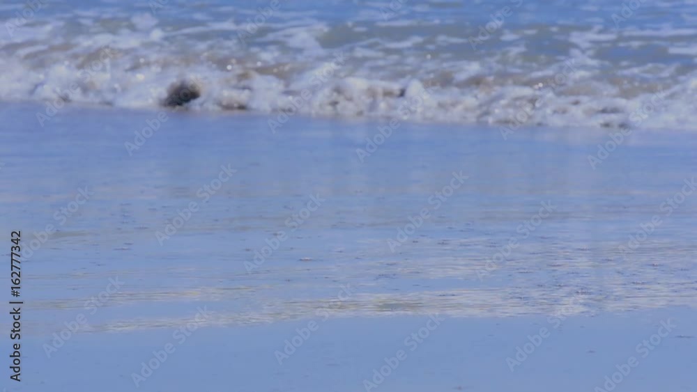 Sand on mediterranean beach with reflection and water slow motion Sand on mediterranean beach with reflection and water slow motion