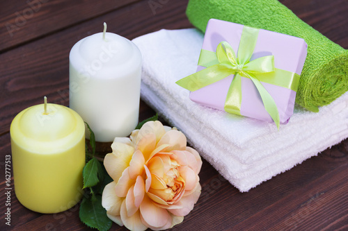 Fragrant candles  soft towels  flowers and presents. Romantic concept. Spa concept.