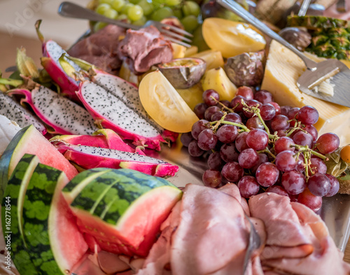 Exotic tray with fruits and cheese on table