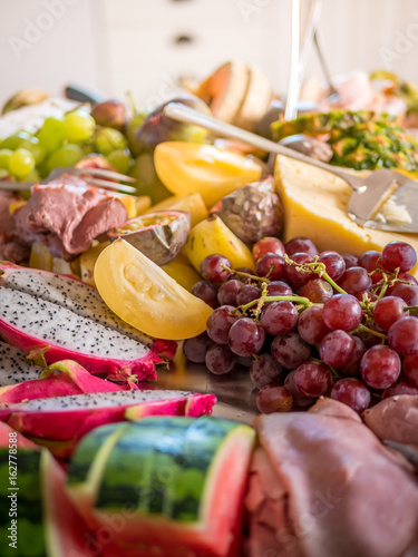 Exotic fruits and cheese on table