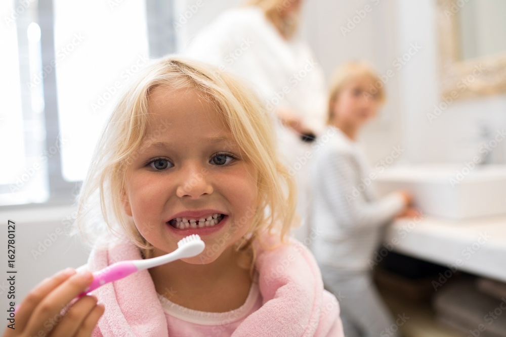 Girl brushing teeth in bathroom Girl brushing teeth in bathroom