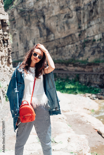 Girl standing near a rock wall © teksomolika