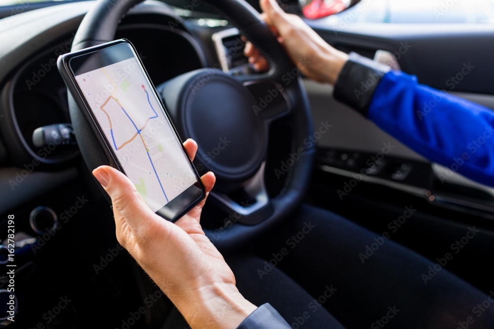 Cropped image of woman using smartphone during test drive Cropped image of woman using smartphone during test drive
