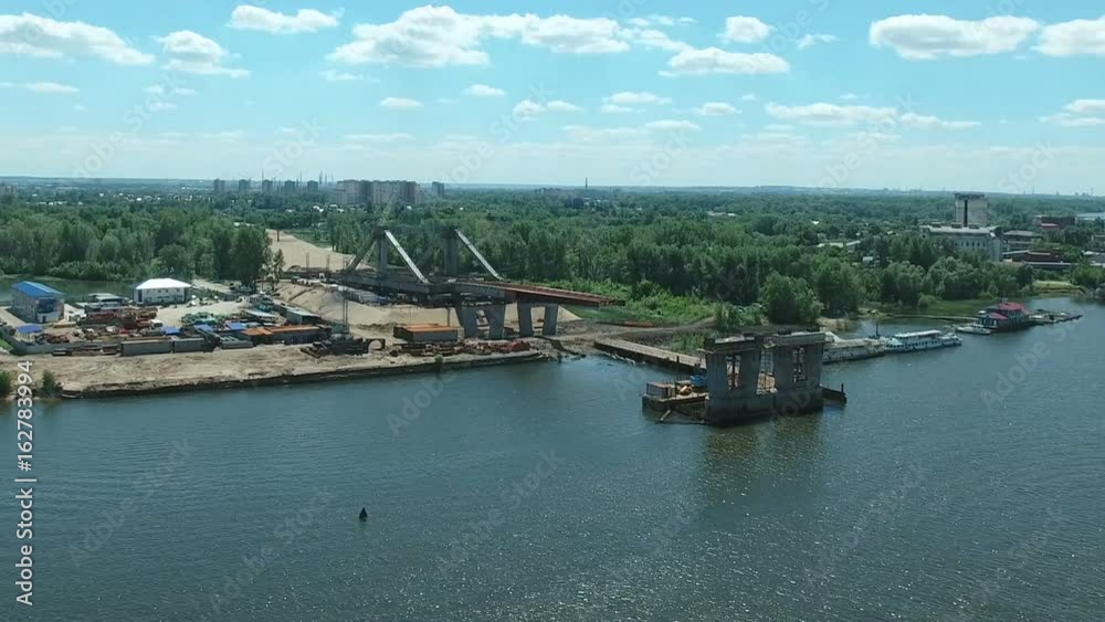 Aerial view of new bridge construction over Samara river against blue sky. Aerial stock footage shot at summer season time. 