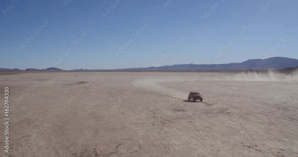 Aerial drone shot of 4x4 off-road truck racing through desert Aerial drone shot of 4x4 off-road truck racing through desert