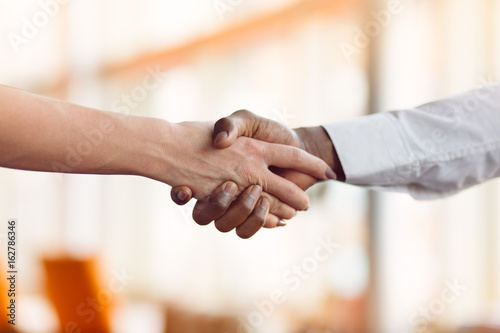 People at work: man and woman hand shaking at a meeting