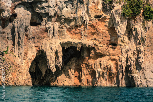 Mountain full of green tree and cliff with deep blue water.