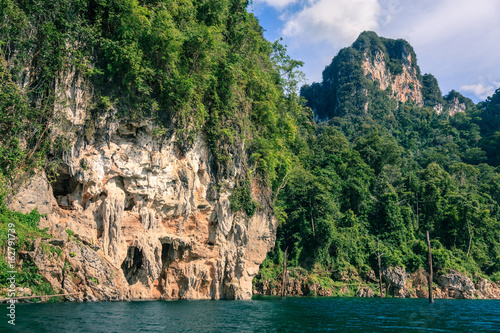 Mountain full of green tree and cliff with deep blue water. © Teeranon