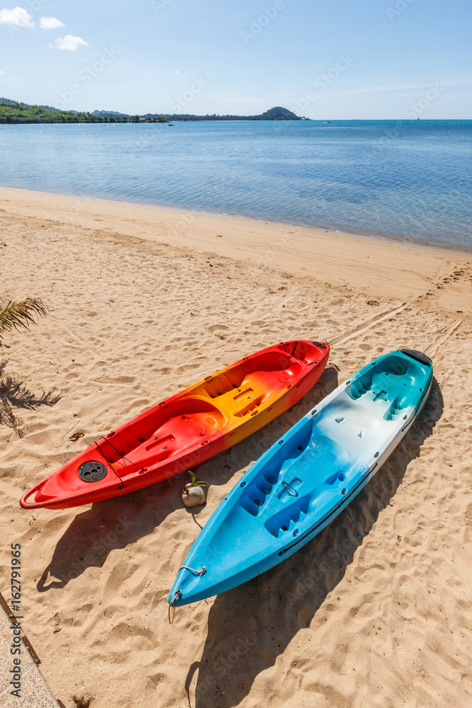 Two colorful empty canoe red and blue on the beach. Two colorful empty canoe red and blue on the beach.