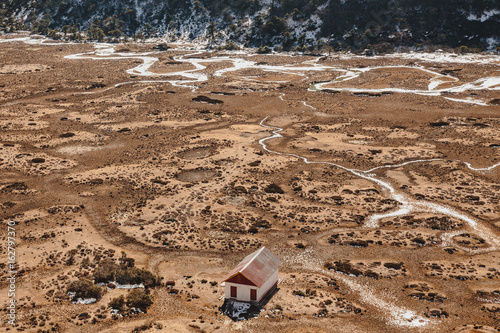 House with glacial traces on yellow stone ground at Thangu and Chopta valley in winter in Lachen. North Sikkim, India. photo