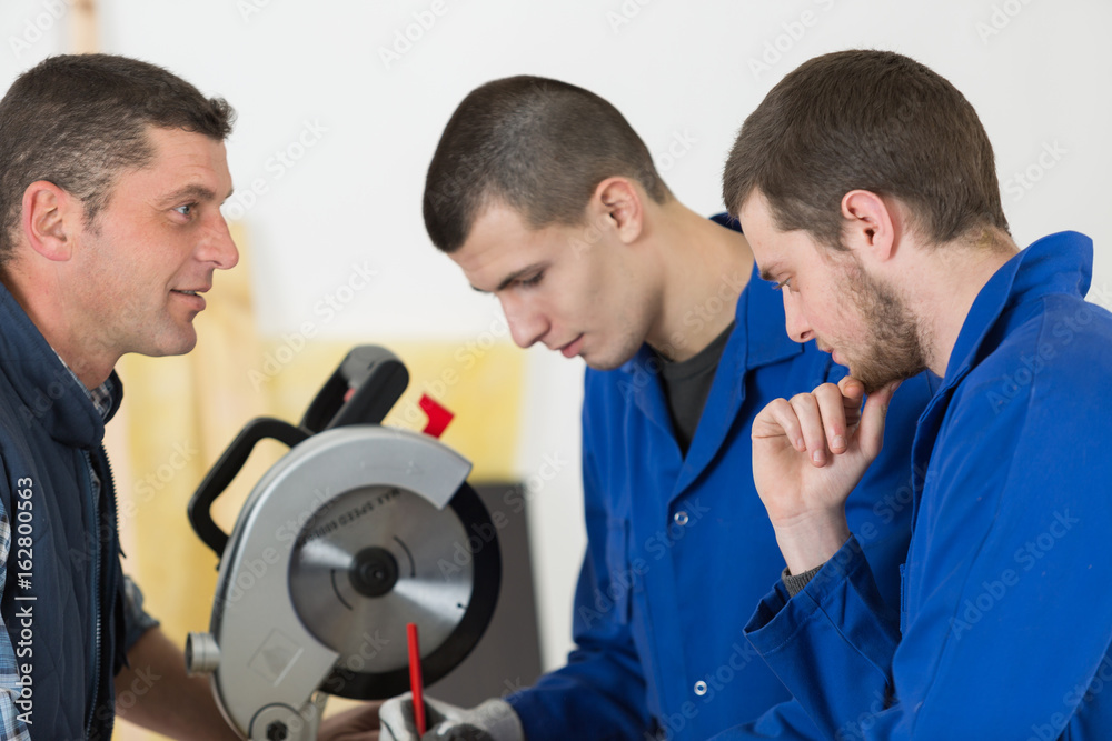 carpenter teaching apprentices how to use a circular saw carpenter teaching apprentices how to use a circular saw