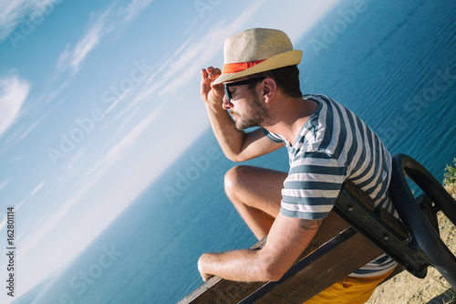 Modern man enjoying the view on the beach. © Kitja