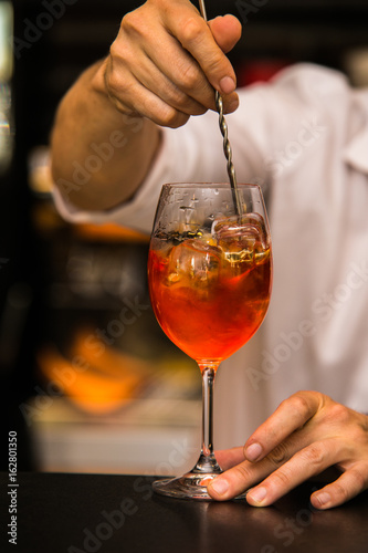 Bartender making a cocktail on bar with fresh fruit.