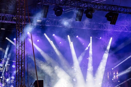 lights beams on stage. blue stage lights at concert. bright spotlights shining down.