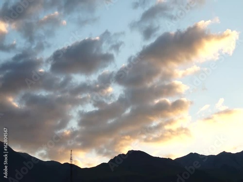 Colored clouds drifting in sunset or sunrise sky, speed up footage