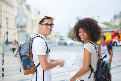 young tourist couple visiting bordeaux holding city map