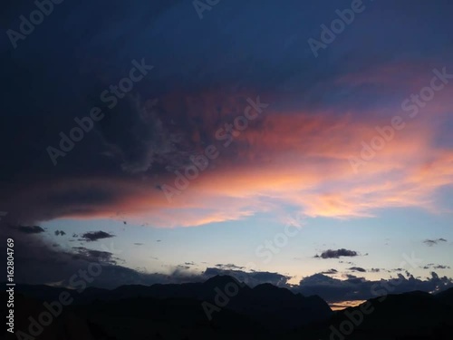 Colored clouds drifting in sunset or sunrise sky, speed up footage