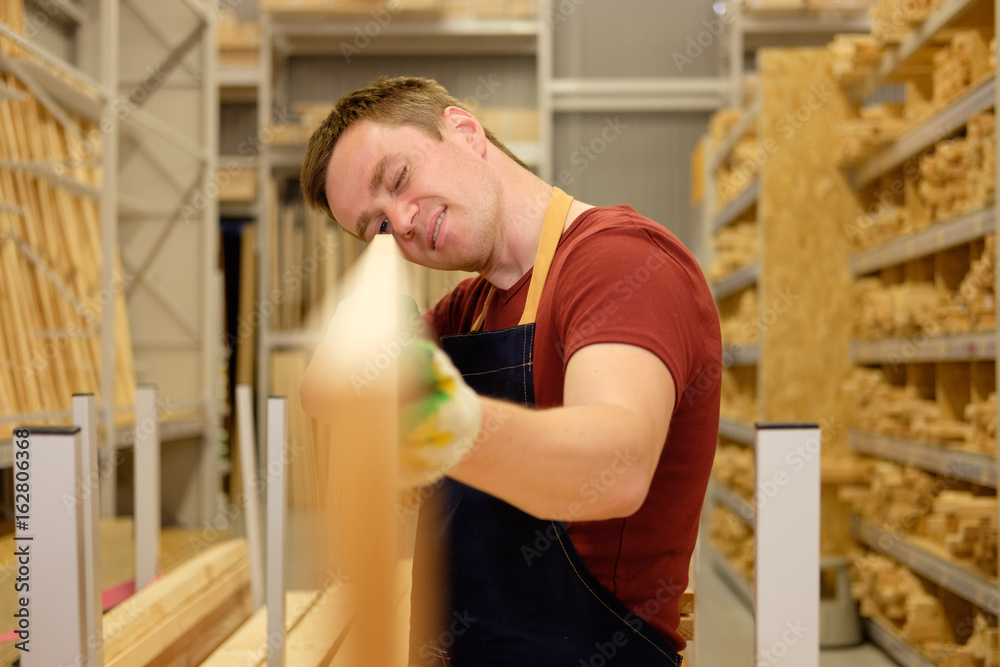 worker or seller in construction store or warehouse wood department at work worker or seller in construction store or warehouse wood department at work