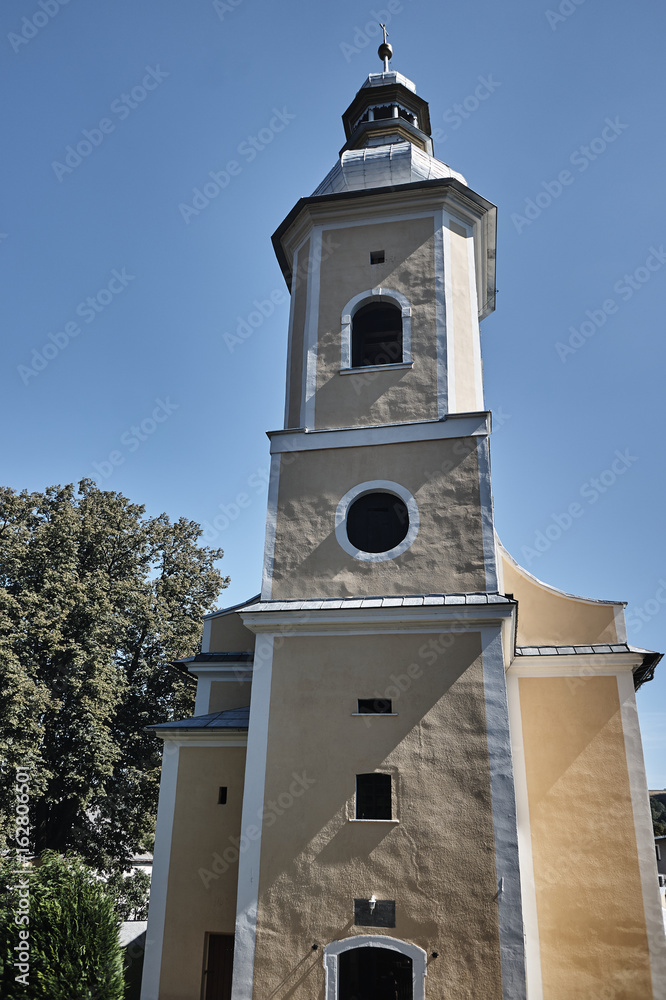Obraz premium The church tower with a clock in Bystrzyca Klodzka in Poland.