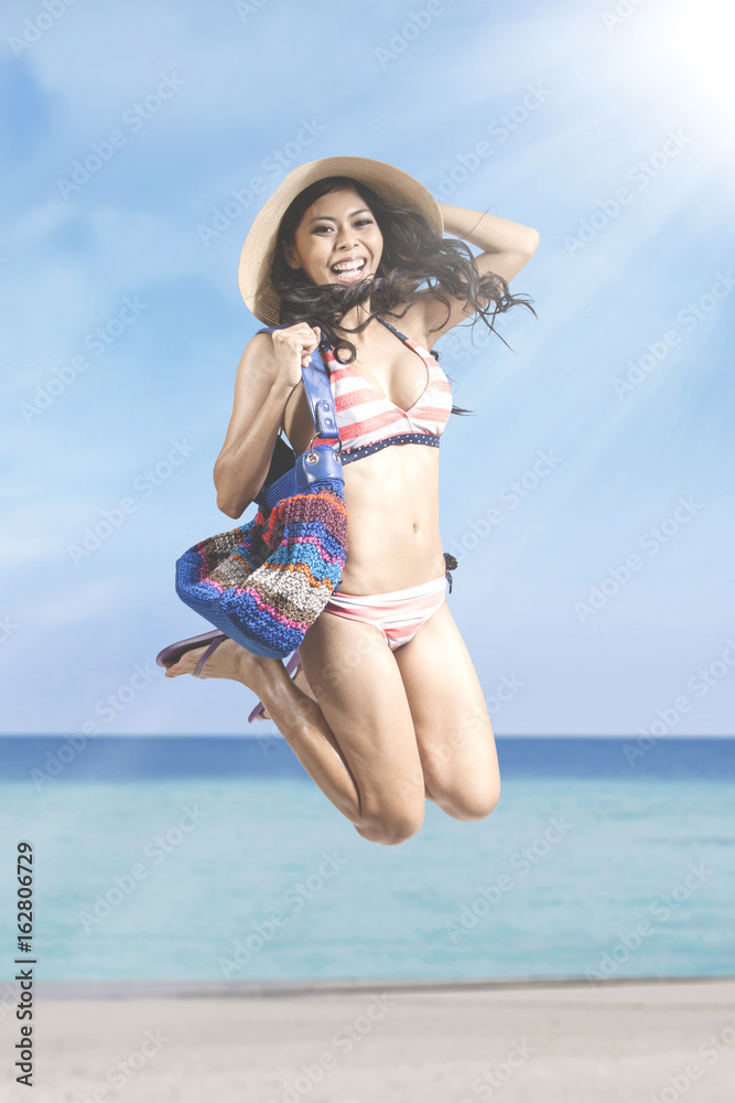 Naklejka premium Happy woman jumps on the beach