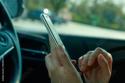 woman using smart phone on the car photo