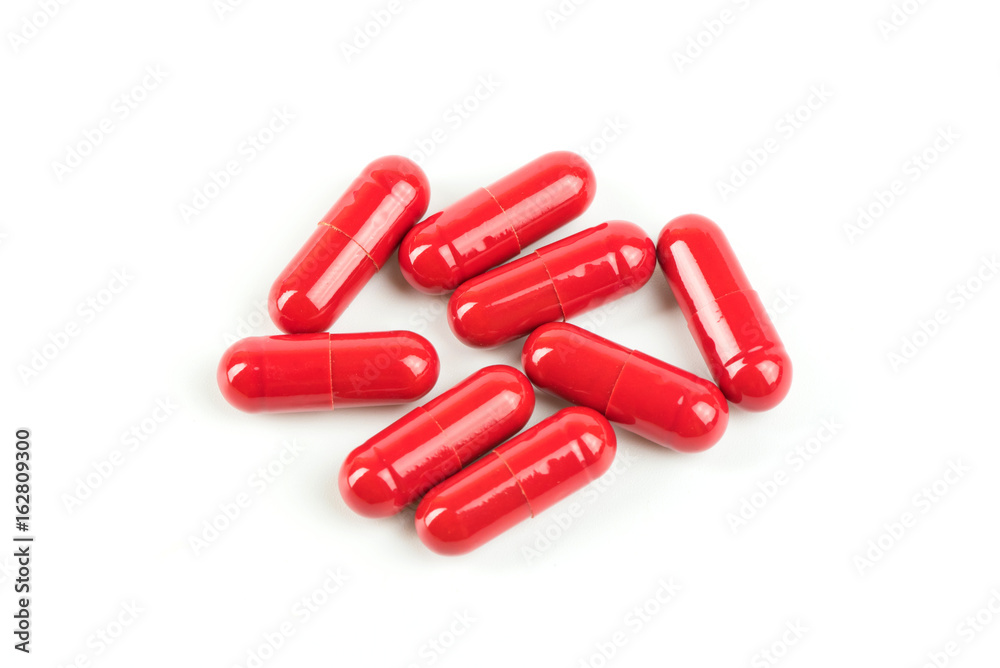 Close up red pill capsules on white background. Close up red pill capsules on white background.