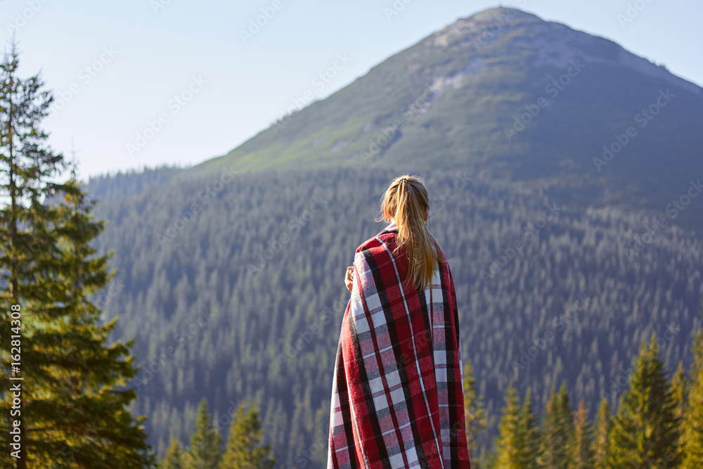 Young blond woman relaxing in mountains