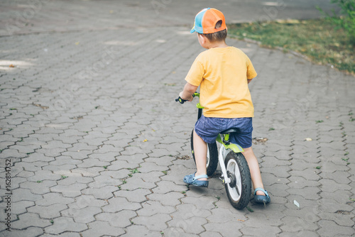 Fototapeta Naklejka Na Ścianę i Meble -  young boy riding strider bike