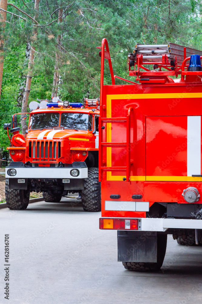 Two fire truck in the park extinguish fire. Assistance to victims Two fire truck in the park extinguish fire. Assistance to victims