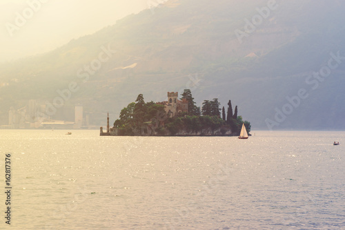 Lake Iseo and the small island of Loreto in the rays of the setting sun, Lombardy, Italy