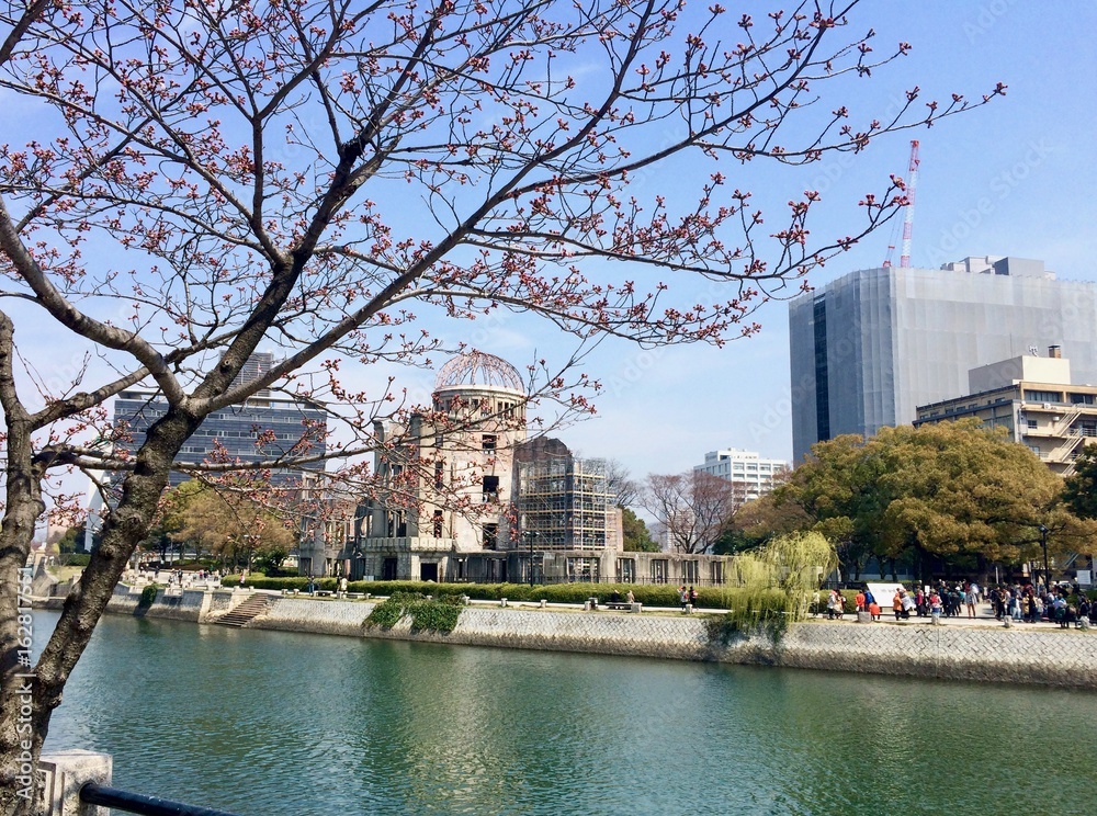 Spring time with beautiful sakura (cherry blossom) at the ruin of the UNESCO World Heritage Site, the Hiroshima Peace Memorial (Atomic Bomb Dome) in Japan (Asia) with a river in front