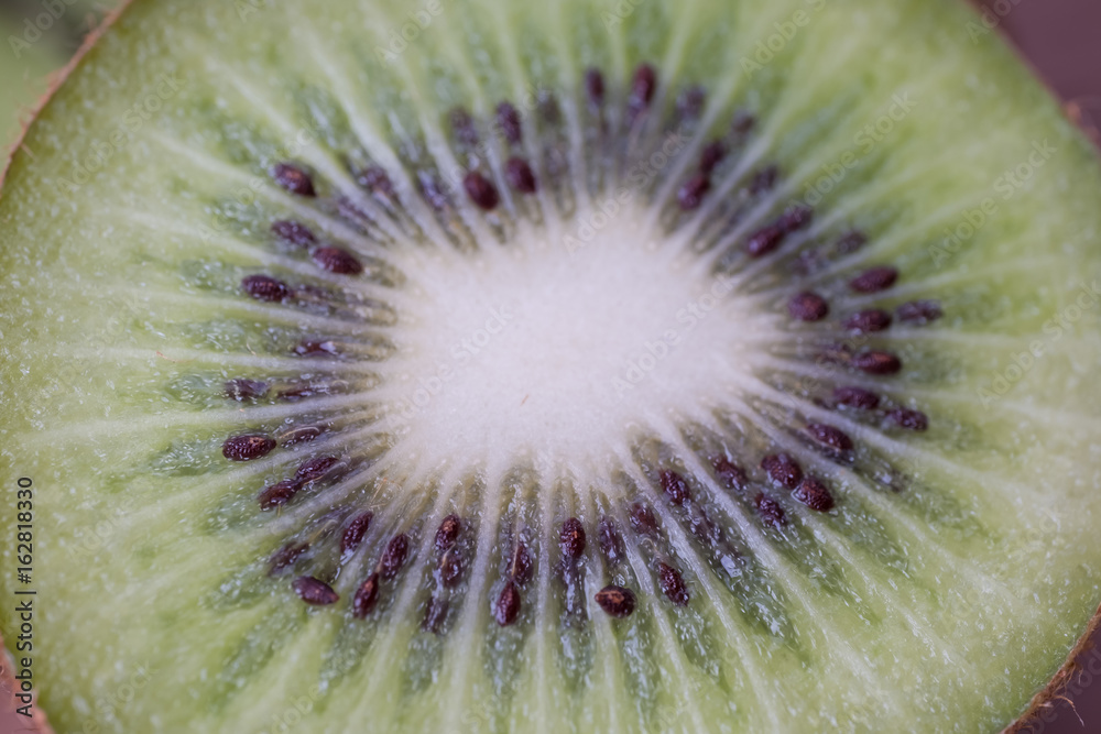 Whole kiwi fruit and sliced segments on wooden plate. Whole kiwi fruit and sliced segments on wooden plate.