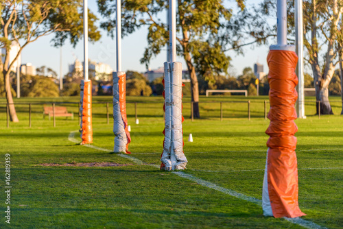 Four Australian football goal posts wrapped with protective padding at a football oval in Carlton, Melbourne, Australia photo