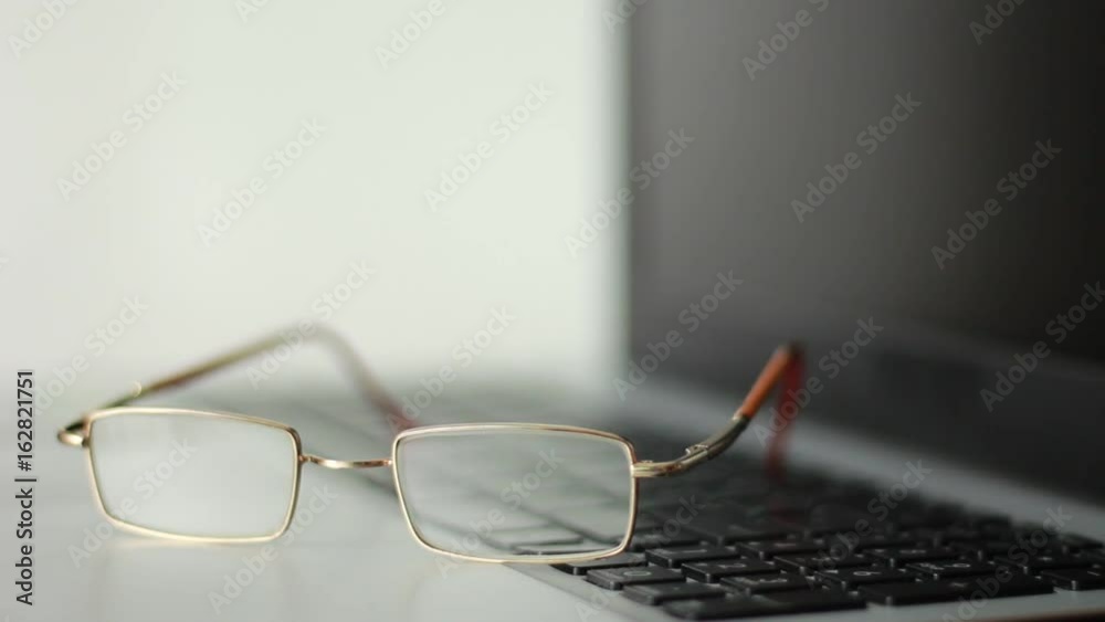 Putting glasses on the notebook and taking it back Putting glasses on the notebook and taking it back
