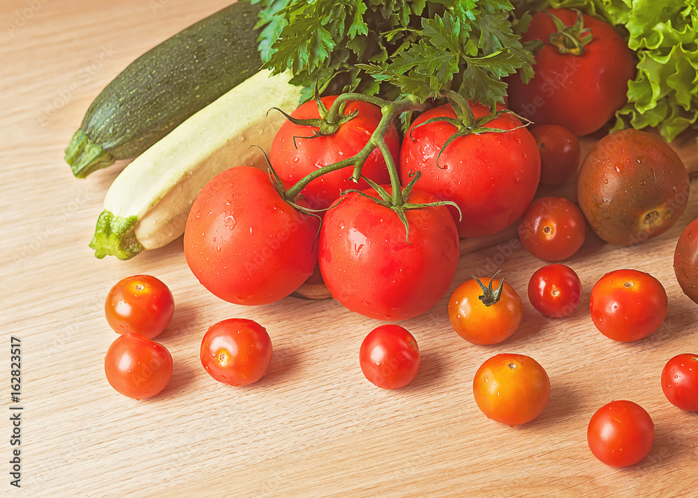 Tomatoes, parsley, zucchini and lettuce on a wooden table. Tomatoes, parsley, zucchini and lettuce on a wooden table.
